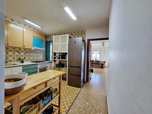 Cocina con nevera y mesa auxiliar