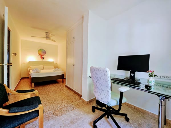 Dormitorio con cama y zona de escritorio